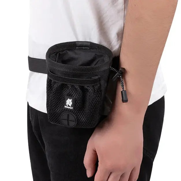 Person wearing a black waist bag with a visible brand logo on a white background